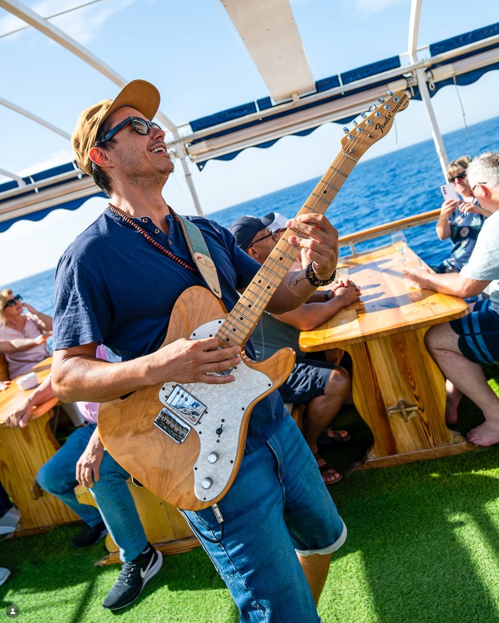 Live Gitarrist spielt akustisch auf dem Sonnendeck der Barca Samba - Live Music Partyboot Mallorca